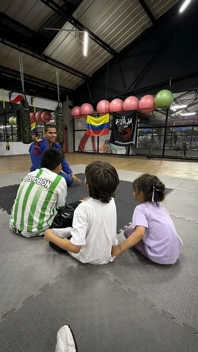Niños atentos a la explicación del coach en la clase de BJJ Kids